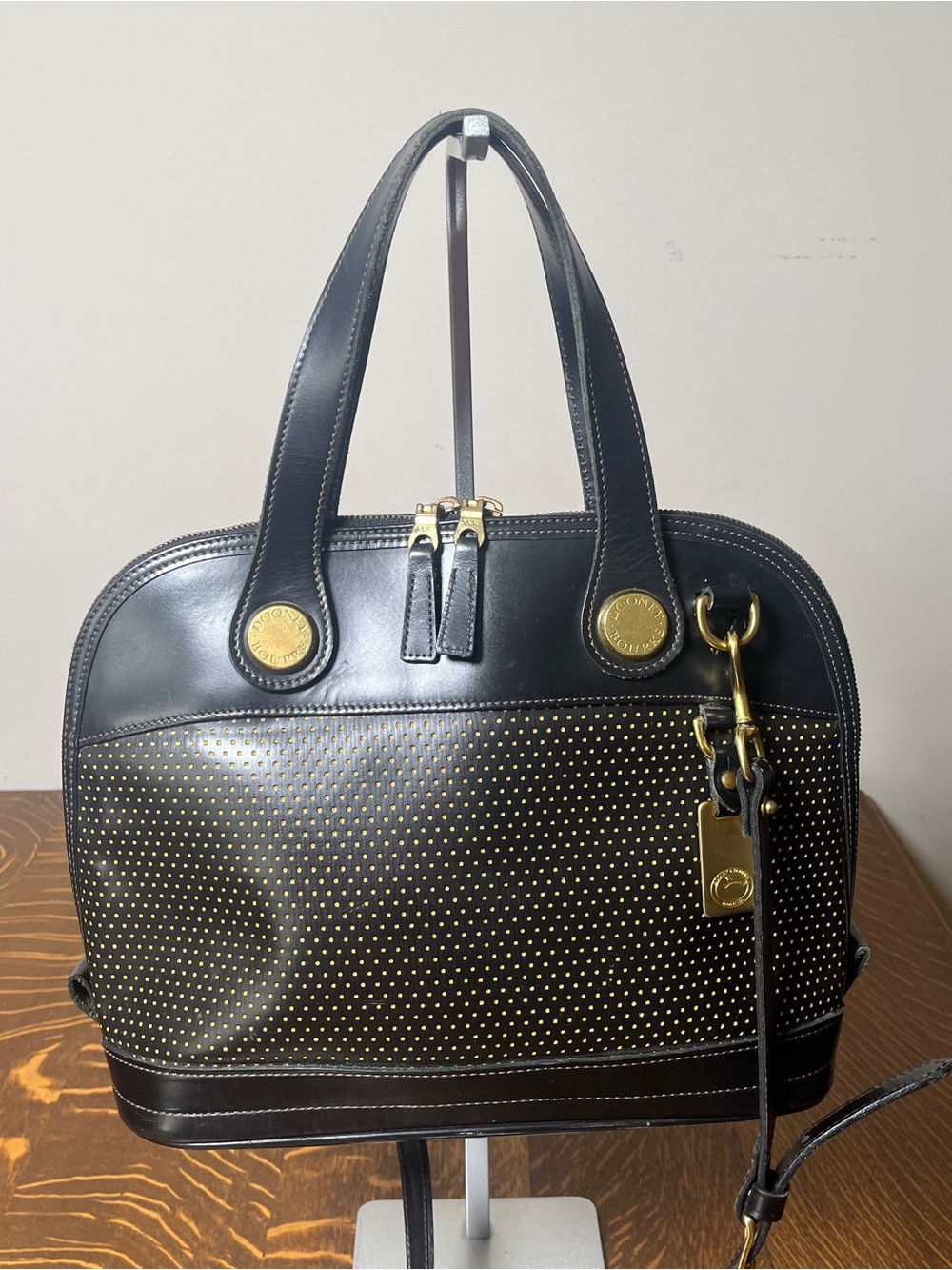 Dooney & Bourke Black Perforated Cabriolet Dome Satchel with Gold Stud Accents.